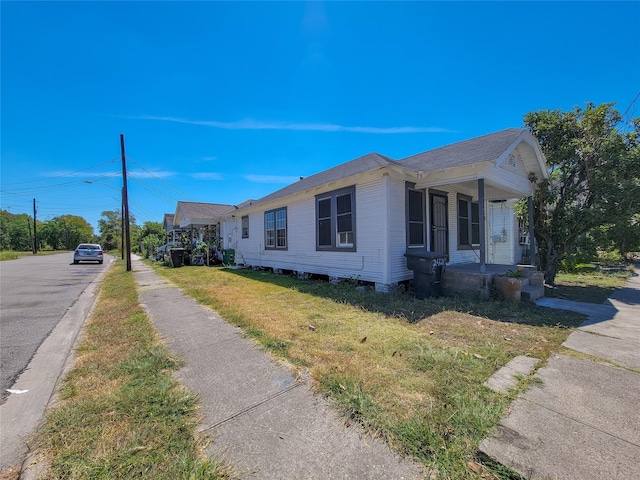 view of home's exterior featuring covered porch and a lawn