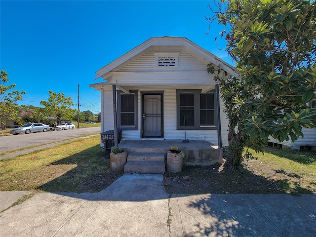 shotgun-style home featuring covered porch