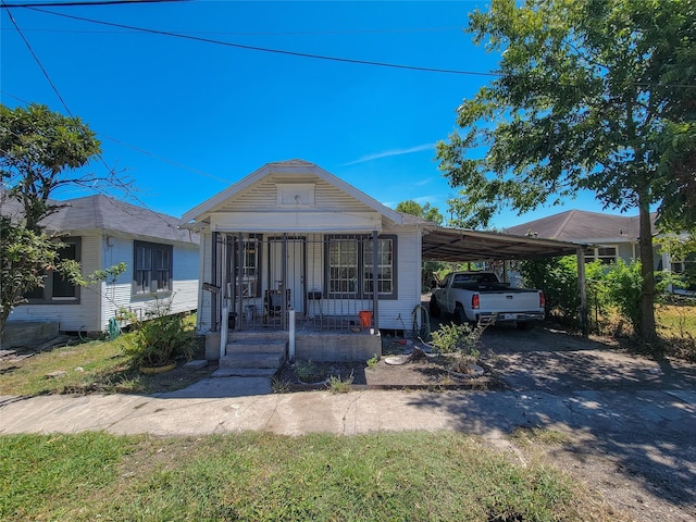 view of front of property featuring a carport, a porch, and driveway