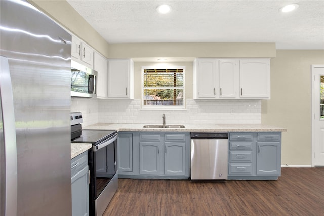 kitchen with white cabinetry, dark wood-style floors, appliances with stainless steel finishes, and a sink