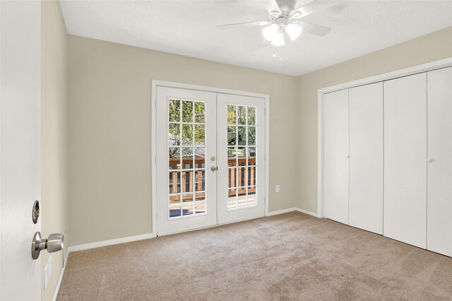 unfurnished bedroom with french doors, carpet floors, a textured ceiling, and access to outside