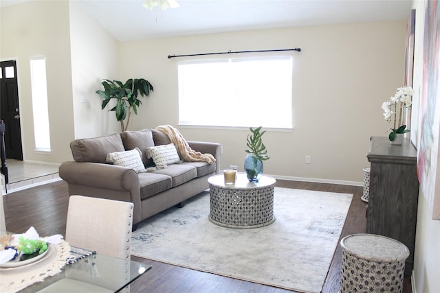 living room with ceiling fan, baseboards, and wood finished floors