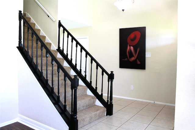 stairway featuring tile patterned floors and baseboards