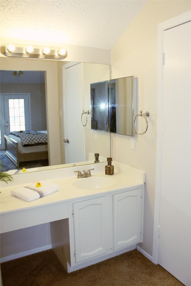 bathroom with vanity, vaulted ceiling, and a textured ceiling