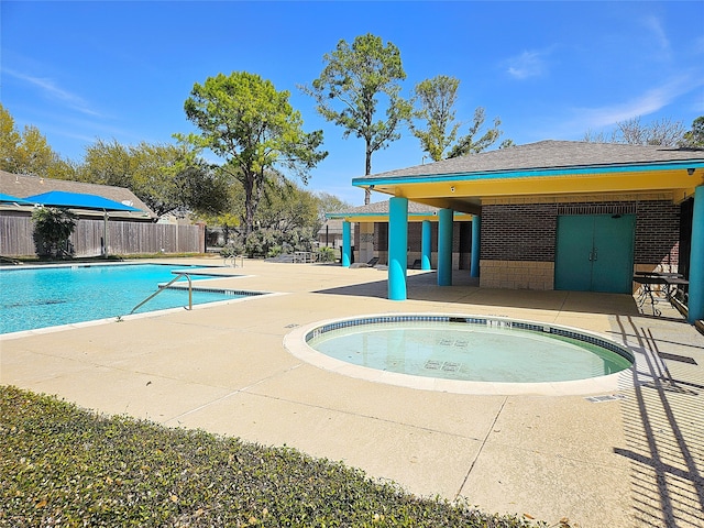 pool featuring fence, a hot tub, and a patio area