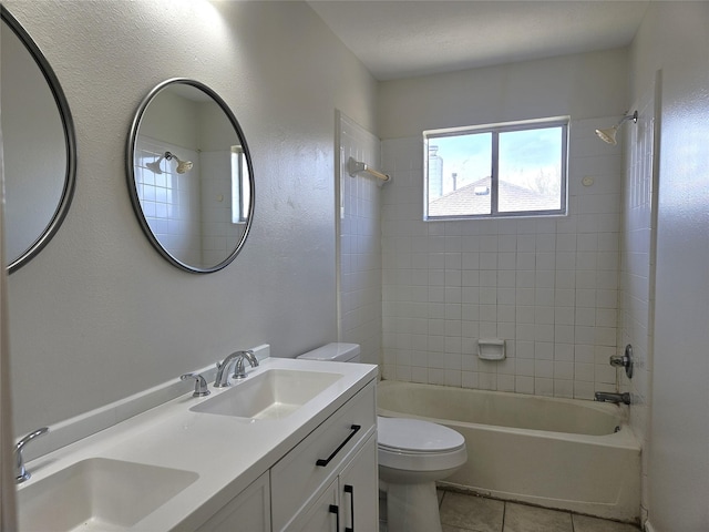 full bath featuring tile patterned floors, toilet, bathing tub / shower combination, and a sink