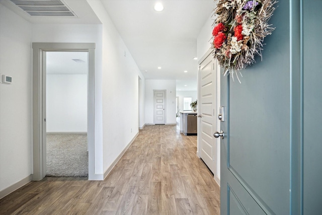 hall featuring recessed lighting, visible vents, baseboards, and light wood finished floors