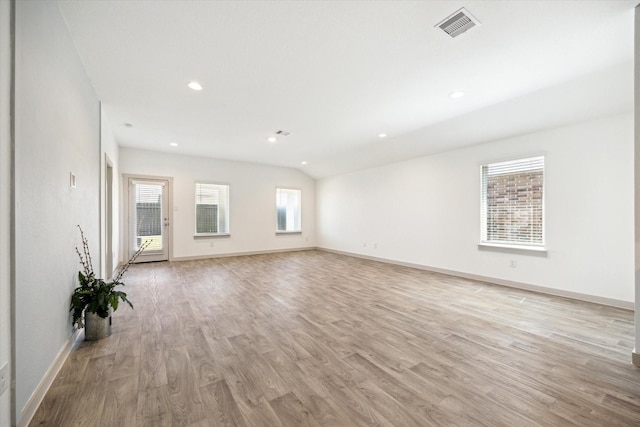 unfurnished living room featuring light wood finished floors, visible vents, baseboards, vaulted ceiling, and recessed lighting