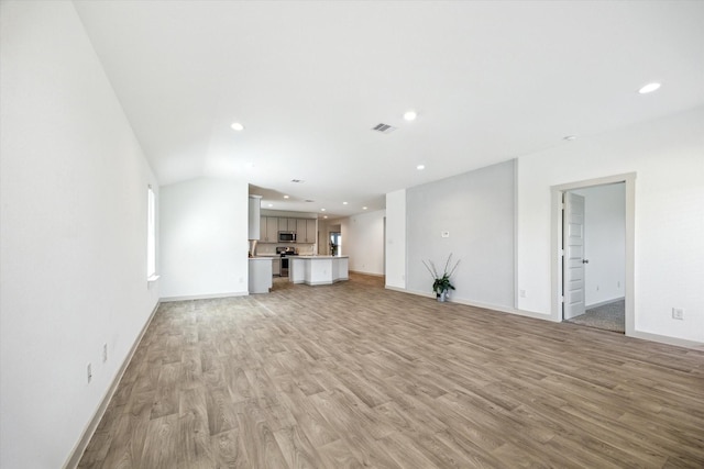 unfurnished living room featuring recessed lighting, light wood-style floors, visible vents, and baseboards