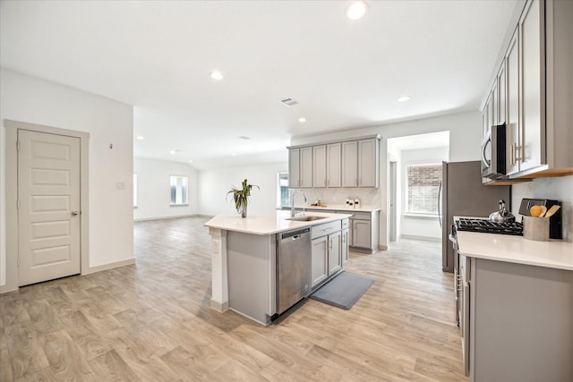 kitchen with a sink, gray cabinetry, plenty of natural light, and stainless steel appliances