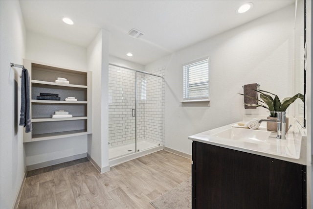 full bathroom with visible vents, a stall shower, wood finished floors, baseboards, and vanity