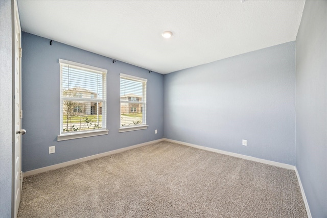 unfurnished room featuring baseboards and carpet