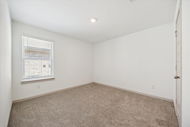 spare room featuring baseboards and carpet floors