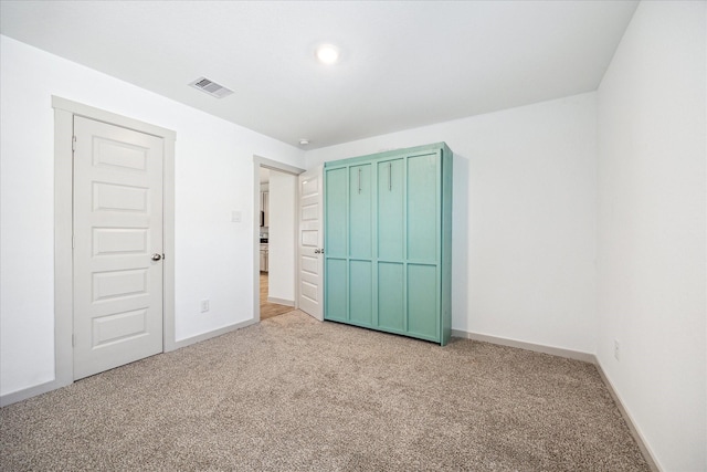 unfurnished bedroom featuring visible vents, light colored carpet, and baseboards