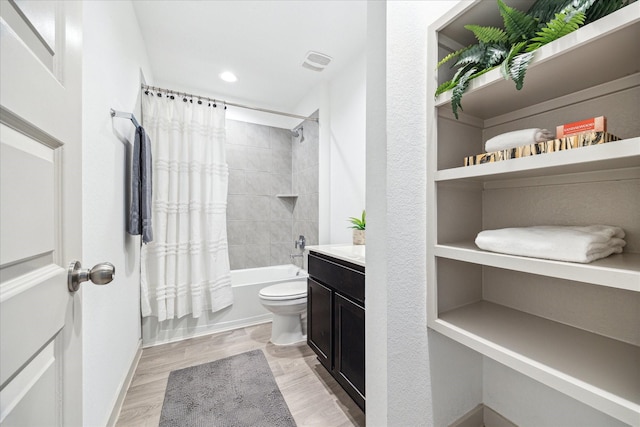 bathroom featuring visible vents, toilet, wood finished floors, shower / tub combo, and vanity