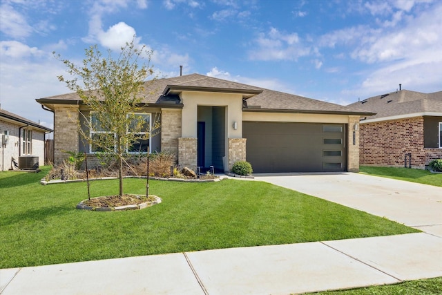 prairie-style home featuring a front lawn, concrete driveway, brick siding, and a garage