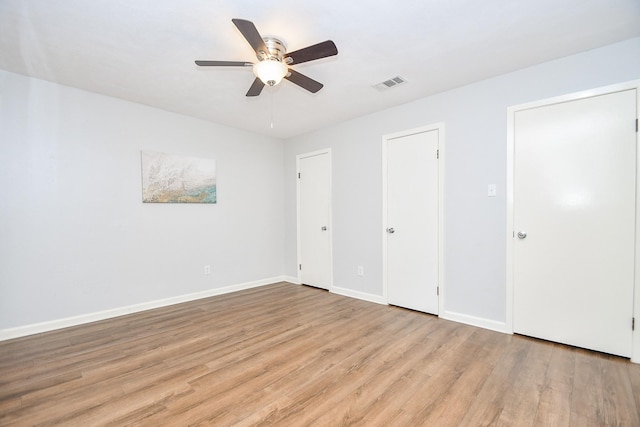 unfurnished bedroom featuring light wood finished floors, visible vents, a ceiling fan, and baseboards