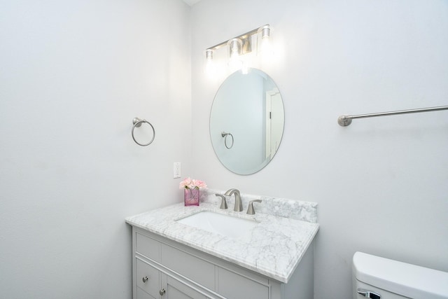 half bathroom featuring vanity and toilet