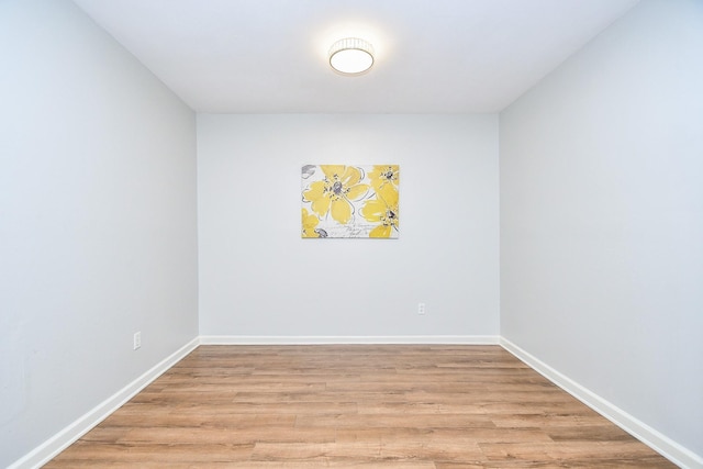 empty room with baseboards and light wood-type flooring