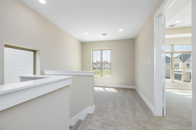 hallway featuring recessed lighting, visible vents, light carpet, and baseboards