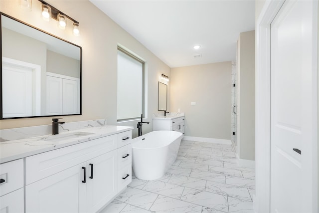 bathroom featuring baseboards, two vanities, a freestanding tub, marble finish floor, and a sink