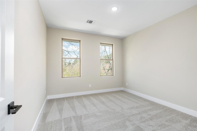 spare room featuring light carpet, visible vents, recessed lighting, and baseboards