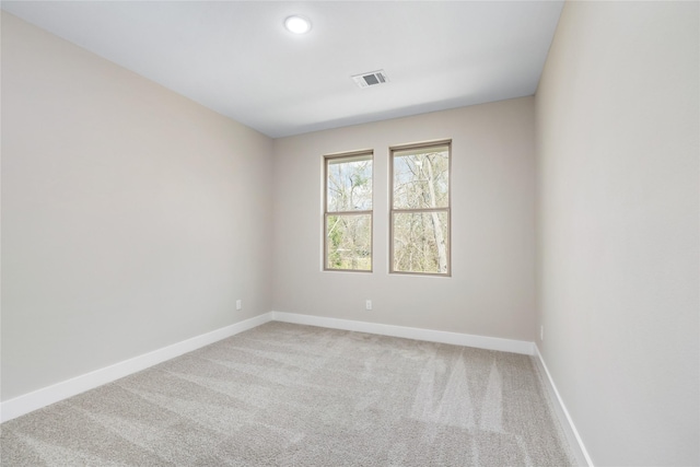 carpeted spare room with visible vents and baseboards