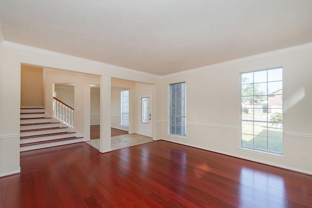 spare room with stairs, crown molding, and wood finished floors