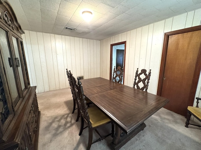 carpeted dining space featuring visible vents