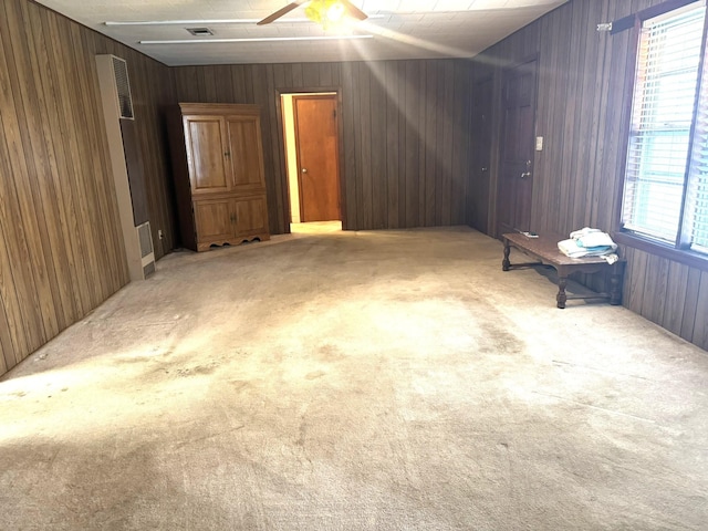 interior space with visible vents, wood walls, and a ceiling fan