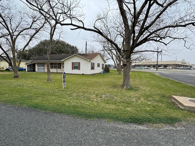 view of front of home with a garage, a front lawn, and aphalt driveway