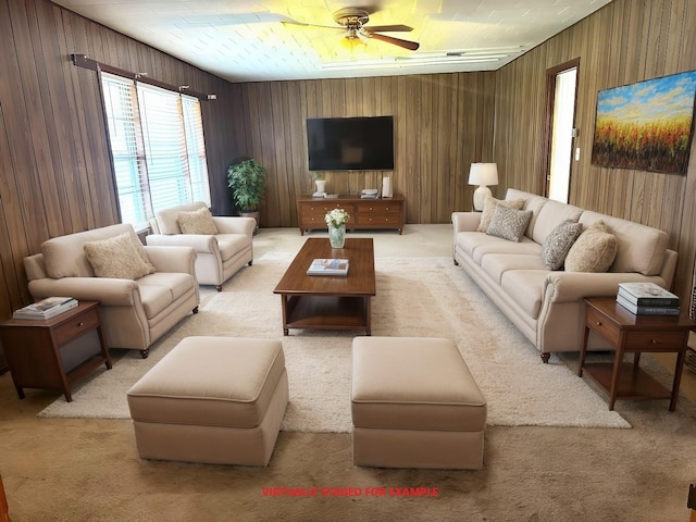 living room featuring wooden walls, light colored carpet, and ceiling fan