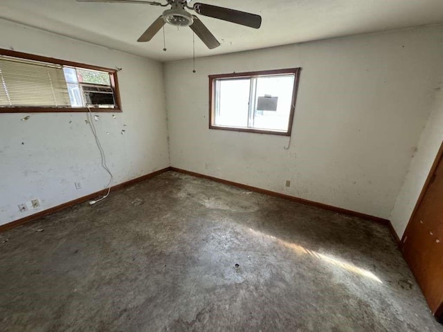 unfurnished bedroom with baseboards, concrete flooring, and ceiling fan