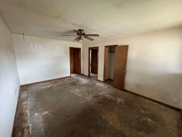 spare room featuring unfinished concrete floors, baseboards, and ceiling fan