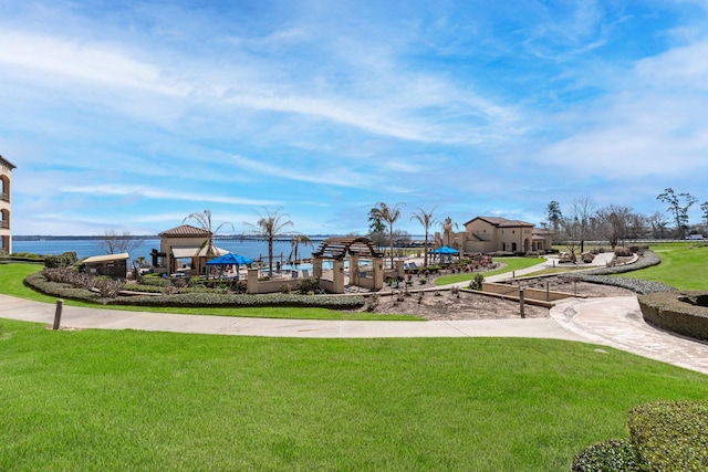 view of playground featuring a gazebo, a lawn, and a water view