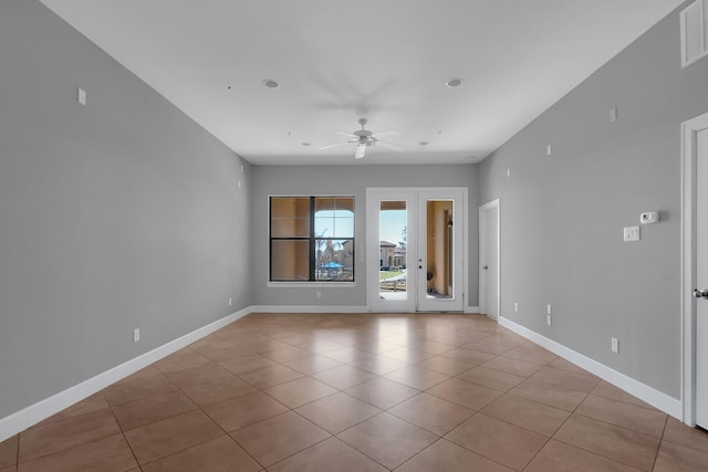 unfurnished room with baseboards, ceiling fan, and light tile patterned flooring