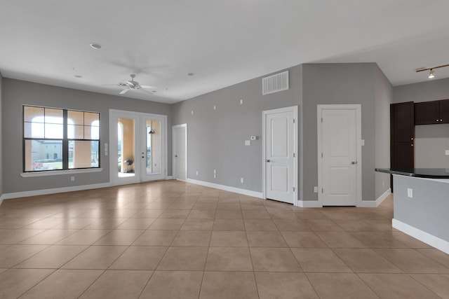 unfurnished living room featuring light tile patterned floors, a ceiling fan, visible vents, and baseboards