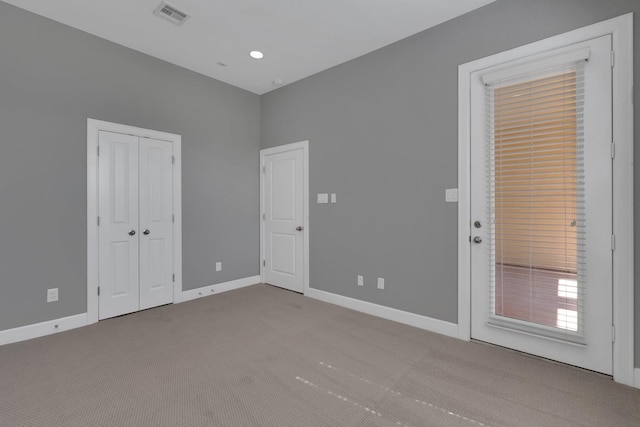 carpeted spare room with visible vents and baseboards