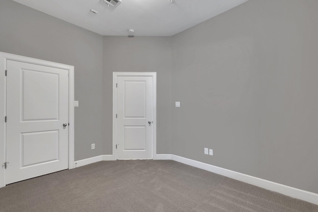 unfurnished room featuring visible vents, baseboards, and carpet