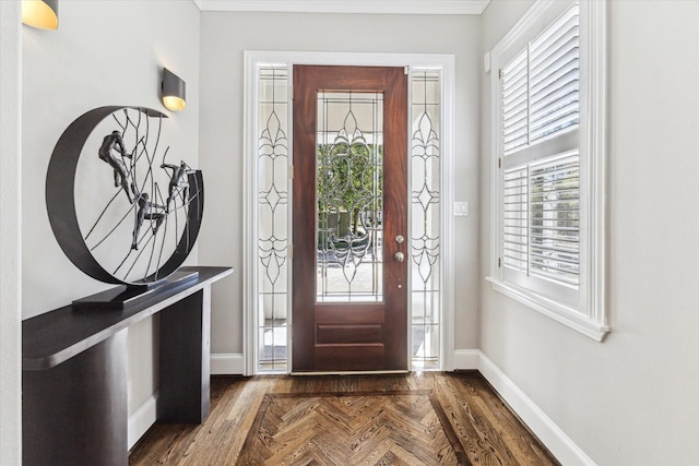 foyer entrance with parquet floors and baseboards