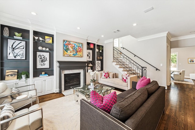 living area with a premium fireplace, stairway, ornamental molding, and wood finished floors