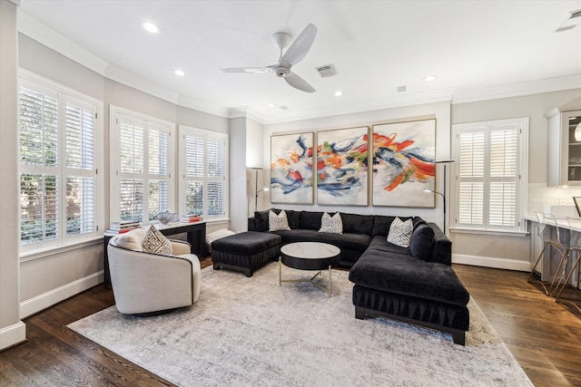 living area with visible vents, wood finished floors, and ornamental molding