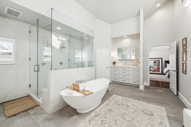 full bathroom featuring a marble finish shower, visible vents, connected bathroom, a freestanding tub, and vanity