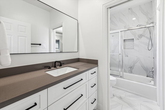 bathroom with vanity, toilet, marble finish floor, and enclosed tub / shower combo