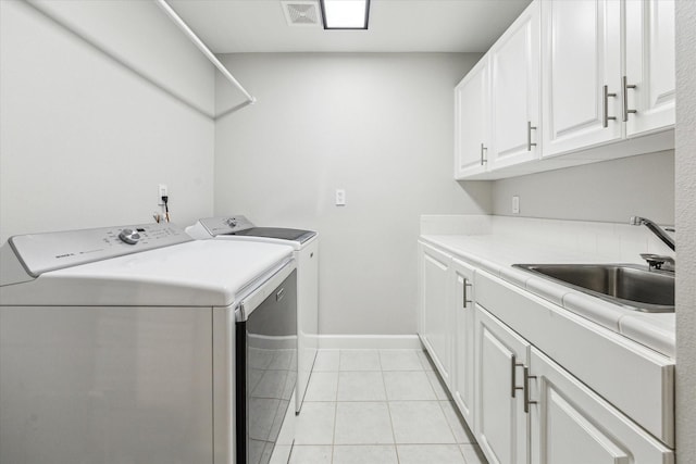 washroom featuring visible vents, a sink, cabinet space, separate washer and dryer, and light tile patterned flooring