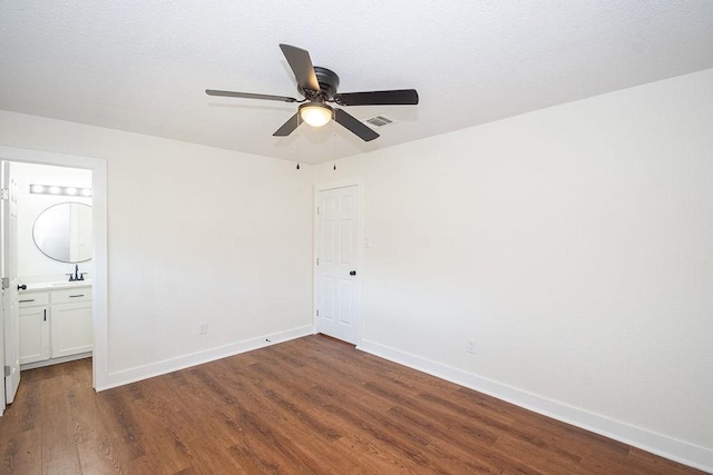 unfurnished bedroom featuring visible vents, a textured ceiling, baseboards, and wood finished floors