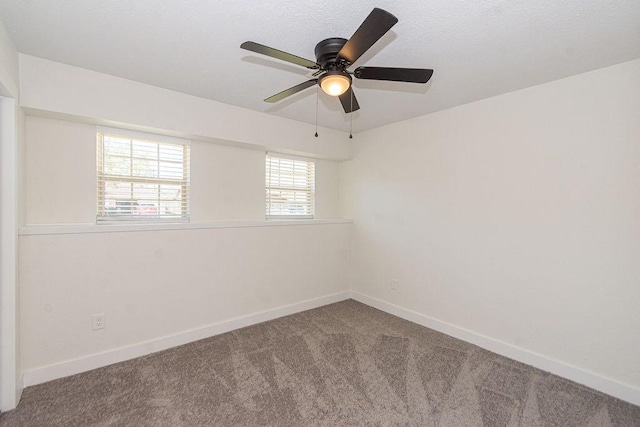 carpeted spare room featuring a ceiling fan, baseboards, and a textured ceiling