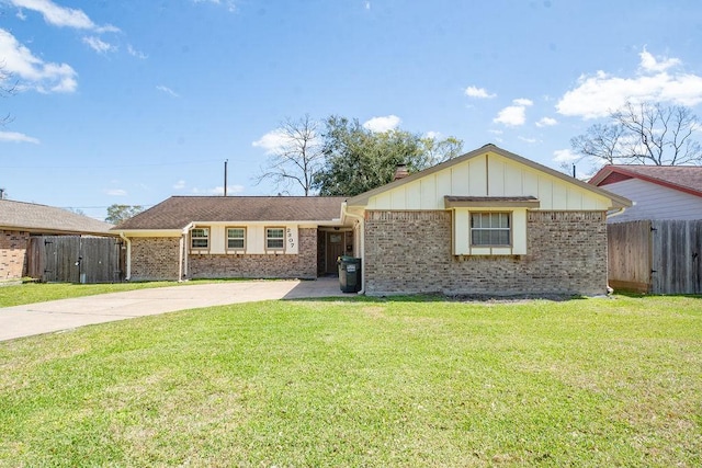 ranch-style house featuring a front lawn, fence, brick siding, and driveway