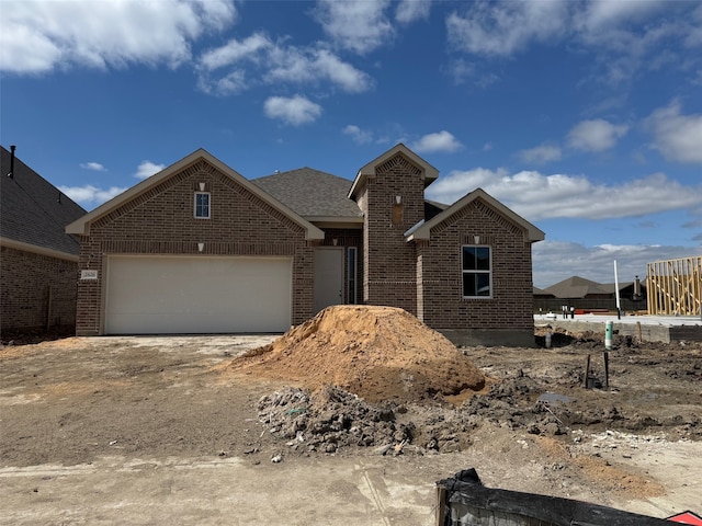 view of front of house featuring an attached garage, brick siding, and driveway