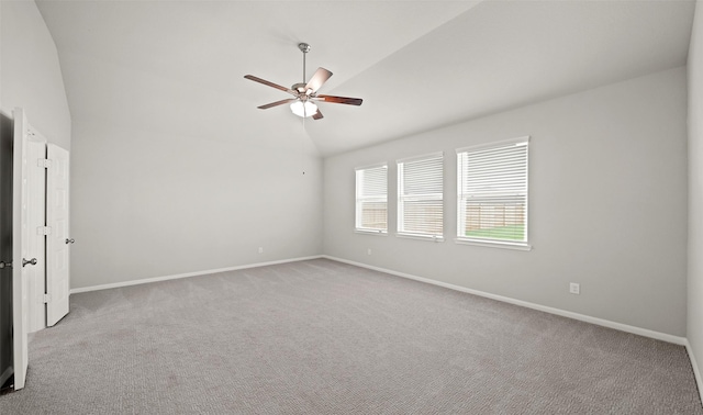 unfurnished room with vaulted ceiling, carpet flooring, baseboards, and ceiling fan